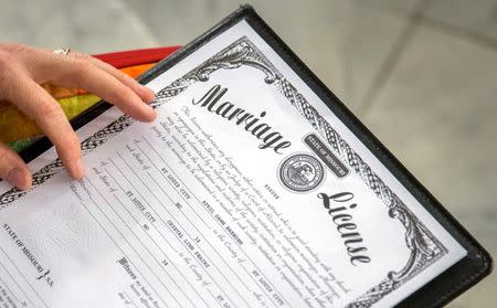 Reverend Katie Hotze-Wilton signs a marriage license at a same-sex wedding ceremony at City Hall in St. Louis, Missouri November 5, 2014. REUTERS/Whitney Curtis