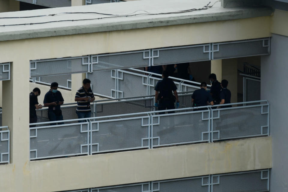 Police officers are seen along a corridor at River Valley High School in Singapore after a 13-year-old boy was found dead on the premises with multiple wounds, while a fellow student was arrested and an axe seized, police said.