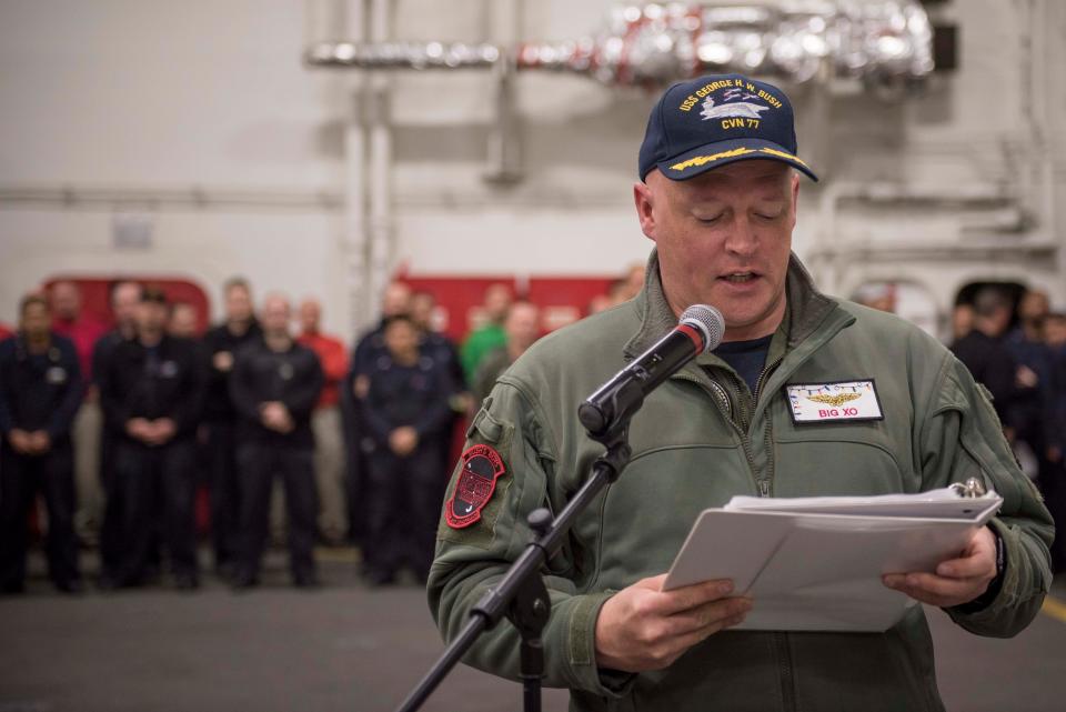 Capt. Chris Hill announces the names of promoted sailors during a ceremony onboard the USS George H.W. Bush in December 2017.