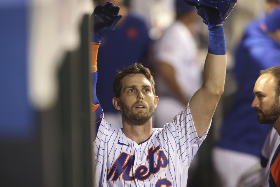 New York Mets' Jeff McNeil celebrates in the dugout after hitting a home run during the seventh inning of a baseball game against the Philadelphia Phillies, Sunday, Sept. 19, 2021, in New York. (AP Photo/Jason DeCrow)