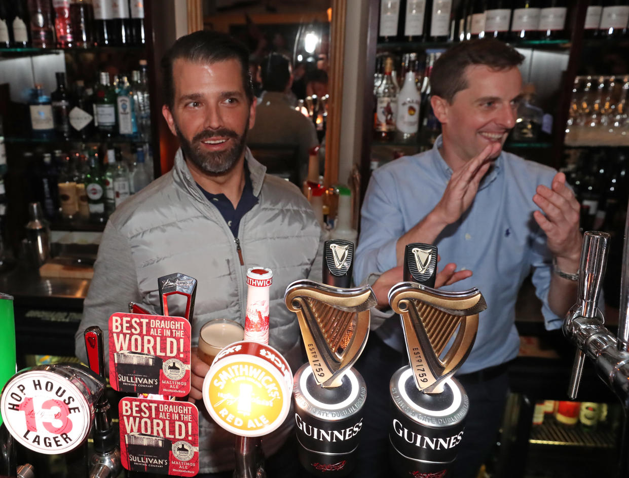 Donald Trump Jr., left, pours drinks and meets locals in the village of Doonbeg in County Clare, Ireland. (Photo Niall Carson/PA Images via Getty Images)