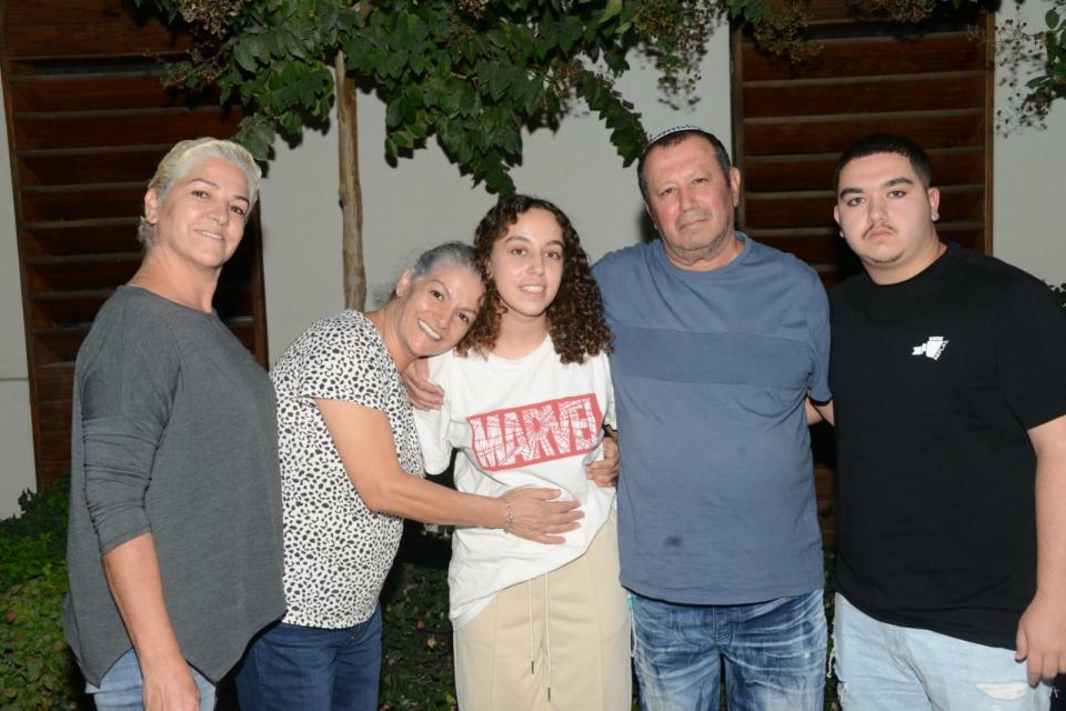 A photo released by the Israeli government on Oct. 30, 2023, shows Israeli Army Pvt. Ori Megidish (center) with family members after she was 