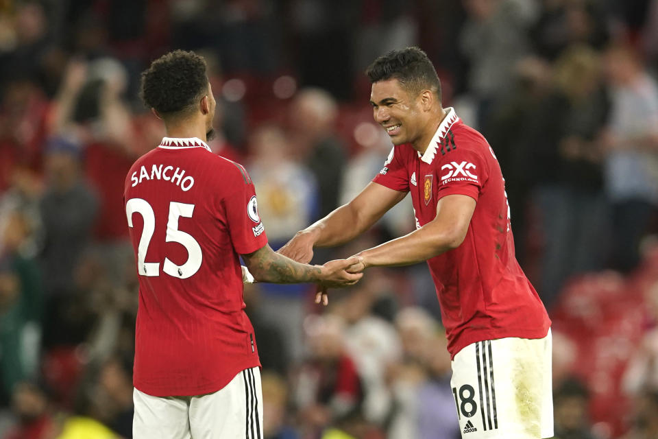 Manchester United's Casemiro, right, and Manchester United's Jadon Sancho celebrate their victory at the English Premier League soccer match between Manchester United and Chelsea at the Old Trafford stadium in Manchester, England, Thursday, May 25, 2023. (AP Photo/Dave Thompson)