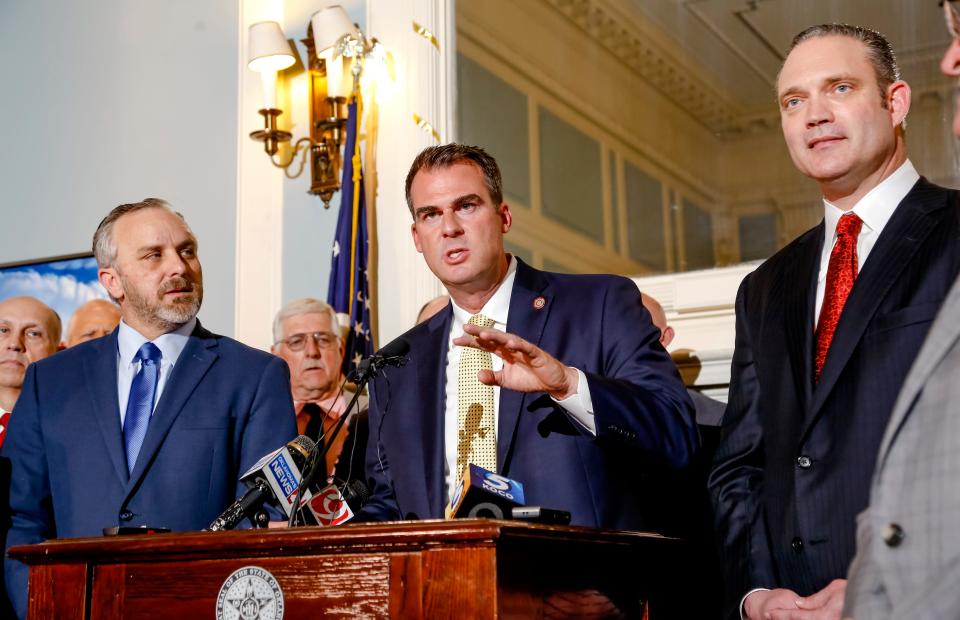 Gov. Kevin Stitt, center, speaks in 2019 as President Pro Tem Greg Treat, left, and Speaker of the House Charles McCall stand at his side as they announce the Fiscal Year 2020 budget deal.