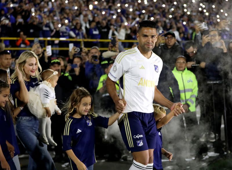 El delantero colombiano Radamel Falcao García, en compañía de su familia, ingresa para su presentación como nuevo jugador de Millonarios al terreno de juego del estadio el Campín de Bogotá