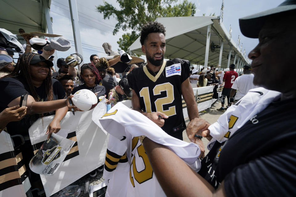 New Orleans Saints wide receiver Chris Olave (12) signs autographs, after training camp at their NFL football training facility in Metairie, La., Saturday, July 30, 2022. (AP Photo/Gerald Herbert)