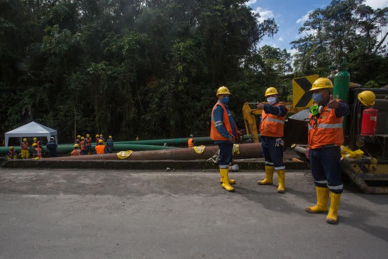 Workers repair a section of oil pipeline about 25 km from the city of Tena in the Amazon