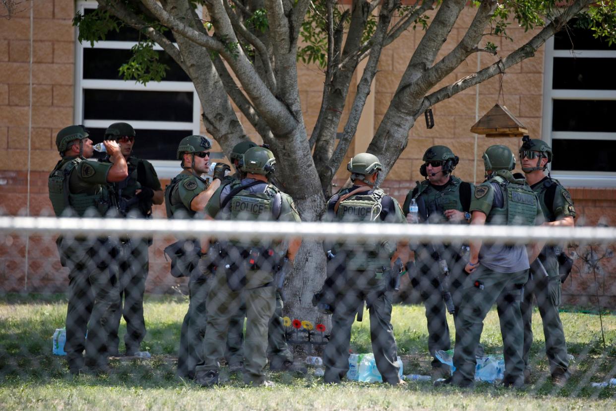 Law enforcement personnel stand outside Robb Elementary School following a shooting, Tuesday, May 24, 2022, in Uvalde, Texas. 