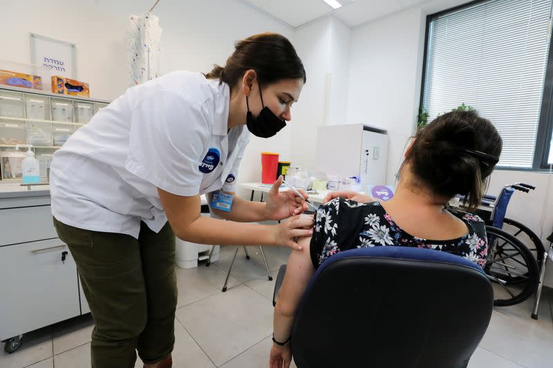 FILE PHOTO: An Israeli woman receives her third dose of the coronavirus disease (COVID-19) vaccine, in Beit Shemesh