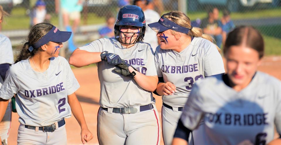 Oxbridge Academy's Chandler Berry is congratulated by her teammates after hitting a home run in the sixth inning against John Carroll Catholic in the District 13-2A softball championship game held at Master's Academy on Thursday, May 4, 2023 in Vero Beach.
