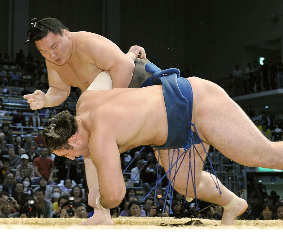 Mongolian-born grand champion Hakuho throws Georgian Tochinoshin to extend his winning streak to 63 at the Kyushu Grand Sumo Tournament in Fukuoka, southwestern Japan, on Nov. 15, 2010. Hakuho is retiring at age 36, marking an end of an era in the history of Japanese traditional sport. The Mongolian-born Yokozuna, or grand champion, Hakuho has won a record 45 tournaments, including 16 perfect victories, which is also a record. (Kyodo News via AP)