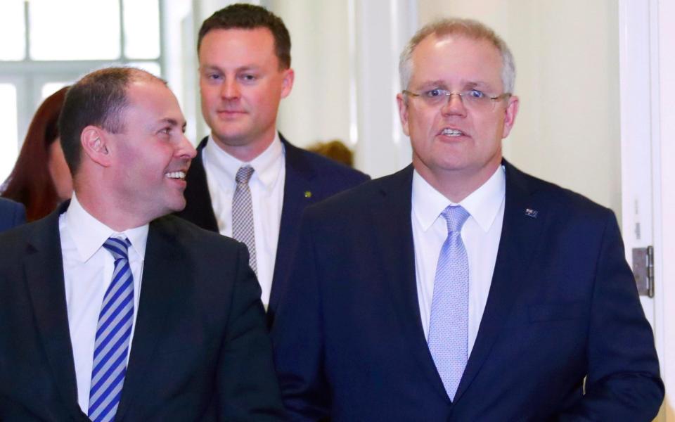 Treasurer of Australia Scott Morrison, right, walks with environment minister Josh Frydenberg, left, after a party meeting in Canberra - POOL Reuters