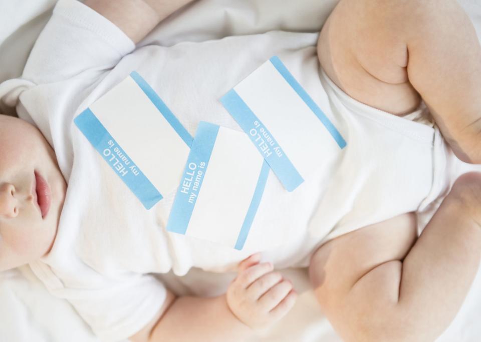 Jamie Grill/Getty Images Stock image of baby with name tags on his onesie