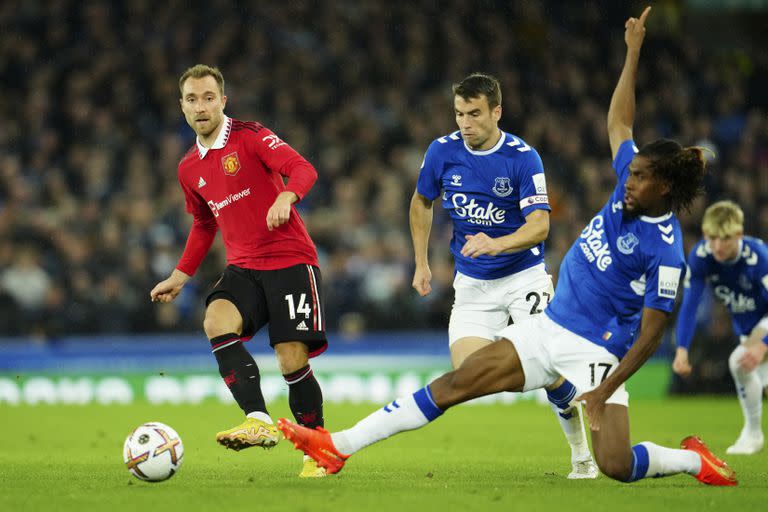 El jugador de Everton Alex Iwobi trata de bloquear un disparo de Christian Eriksen, de Manchester United, en un partido de la Liga Premier inglesa el 9 de octubre del 2022 en Liverpool.  (AP Foto/Jon Super)