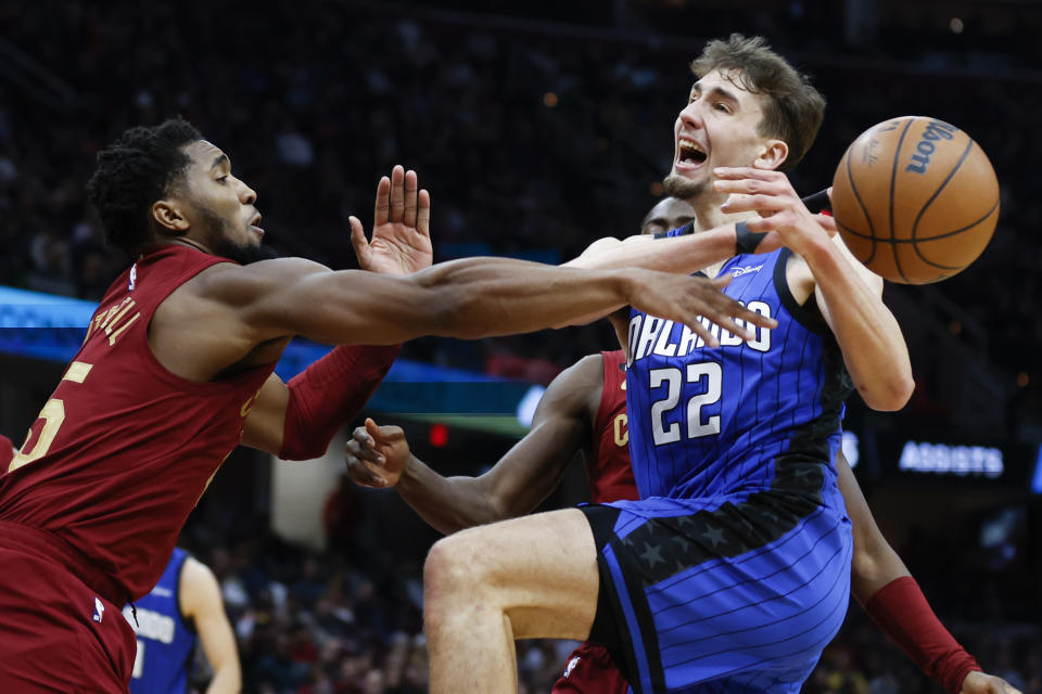 Cleveland Cavaliers guard Donovan Mitchell, left, knocks the ball away from Orlando Magic forward Franz Wagner (22) during the second half of an NBA basketball game, Friday, Dec. 2, 2022, in Cleveland. (AP Photo/Ron Schwane)