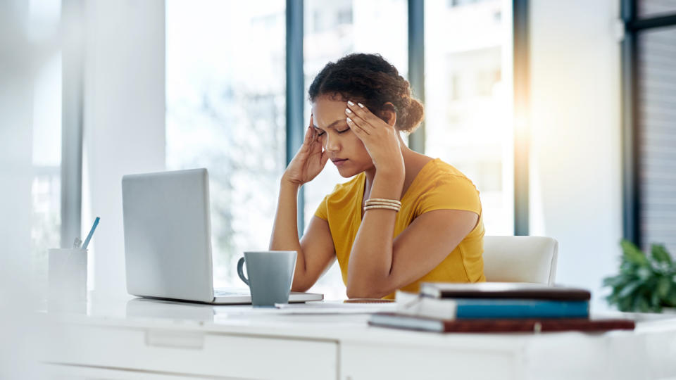 A young designer looking stressed out while working in an office.