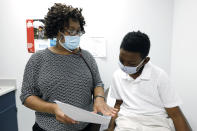 Jeremiah Young, 11, right, listens as Dr. Janice Bacon, a primary care physician, with Central Mississippi Health Services in Hinds County, explains the necessity of receiving inoculations prior to attending school, Aug. 14, 2020, while at the Community Health Care Center on the Tougaloo College campus in Tougaloo, Miss. Bacon and the staff of medical and mental health care professionals, provide personalized care to a population that is overwhelmingly Black and where there have been the most positive cases of coronavirus reported in the state. (AP Photo/Rogelio V. Solis)