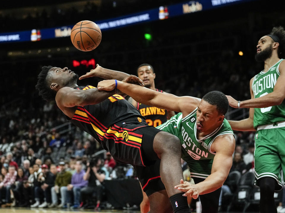 Atlanta Hawks center Clint Capela (15) is fouled by Boston Celtics forward Grant Williams (12) as he drives to the basket during the first half of an NBA basketball game Wednesday, Nov. 16, 2022 in Atlanta. (AP Photo/John Bazemore)