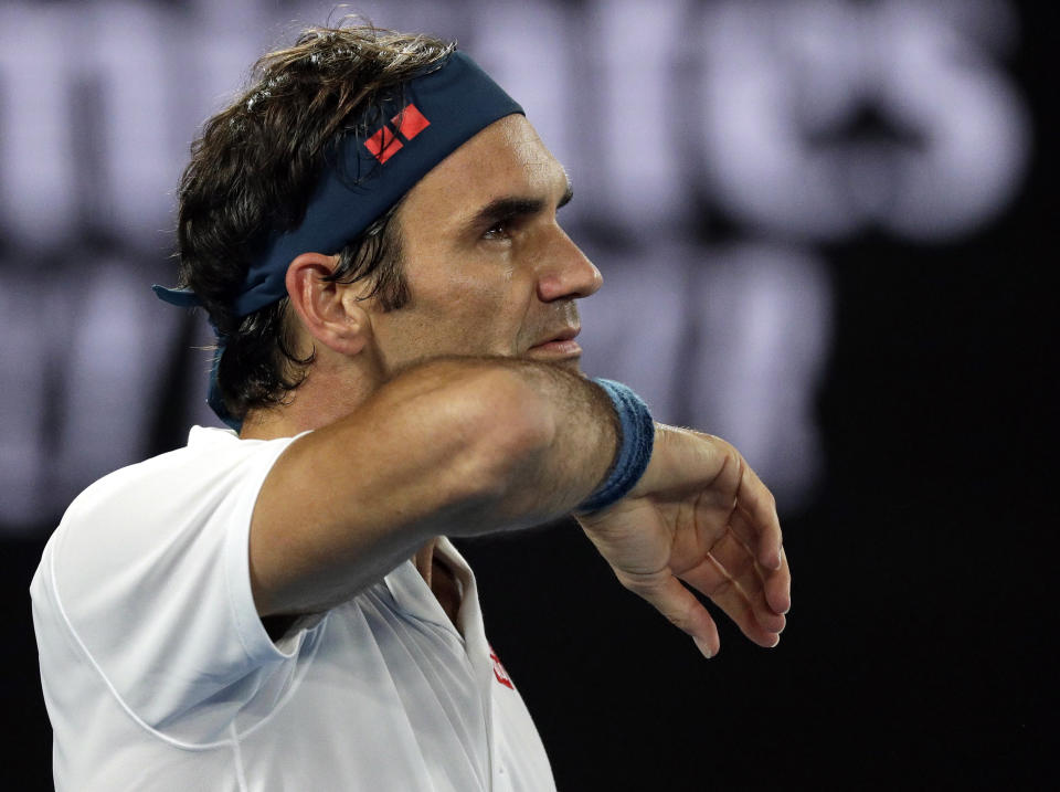 Switzerland's Roger Federer wipes the sweat from his face during his third round match against United States' Taylor Fritz at the Australian Open tennis championships in Melbourne, Australia, Friday, Jan. 18, 2019. (AP Photo/Kin Cheung)