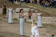 Olympics - Dress Rehearsal - Lighting Ceremony of the Olympic Flame Pyeongchang 2018 - Ancient Olympia, Olympia, Greece - October 23, 2017 Greek actress Katerina Lehou, playing the role of High Priestess, passes the flame to the first torchbearer, Greek cross country skiing athlete Apostolos Aggelis, during the dress rehearsal for the Olympic flame lighting ceremony for the Pyeongchang 2018 Winter Olympic Games at the site of ancient Olympia in Greece REUTERS/Alkis Konstantinidis