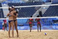 April Ross, left, of the United States, hugs teammate Alix Klineman during a women's beach volleyball match against Cuba at the 2020 Summer Olympics, Monday, Aug. 2, 2021, in Tokyo, Japan. (AP Photo/Petros Giannakouris)