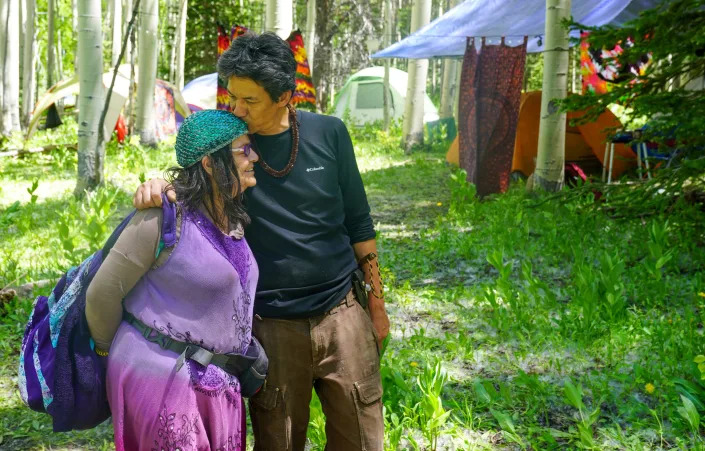 Rainbow Family attendees hug in reunion during preparations for the annual campout, this year held in a remote part of Routt National Forest in Colorado. Sunday, June 26, 2022