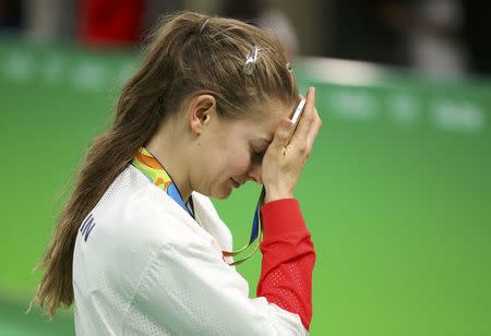 2016 Rio Olympics - Trampoline Gymnastics - Victory Ceremony - Women's Victory Ceremony - Rio Olympic Arena - Rio de Janeiro, Brazil - 12/08/2016. Bryony Page (GBR) of Britain reacts with her medal on the podium after the women's trampoline final. REUTERS/Mike Blake