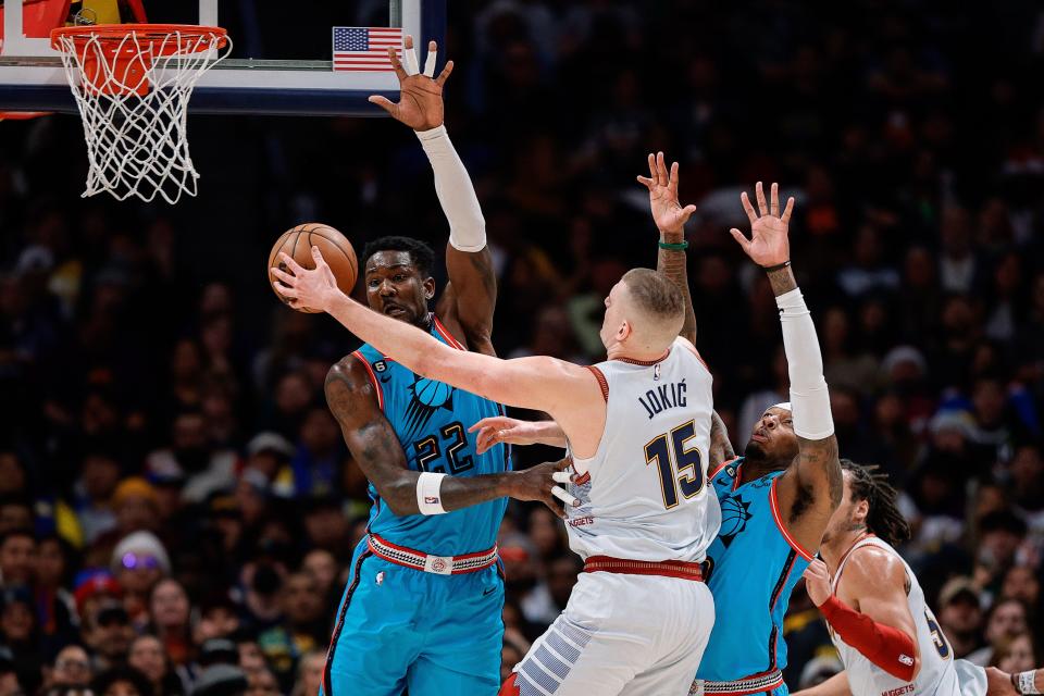 Dec 25, 2022; Denver, Colorado, USA; Denver Nuggets center Nikola Jokic (15) drives to the net against Phoenix Suns center Deandre Ayton (22) and forward Torrey Craig (0) in the second quarter at Ball Arena.