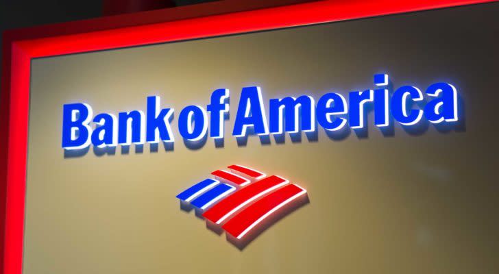 A photo of the Bank of America (BAC) logo in neon red and blue on a tan wall.