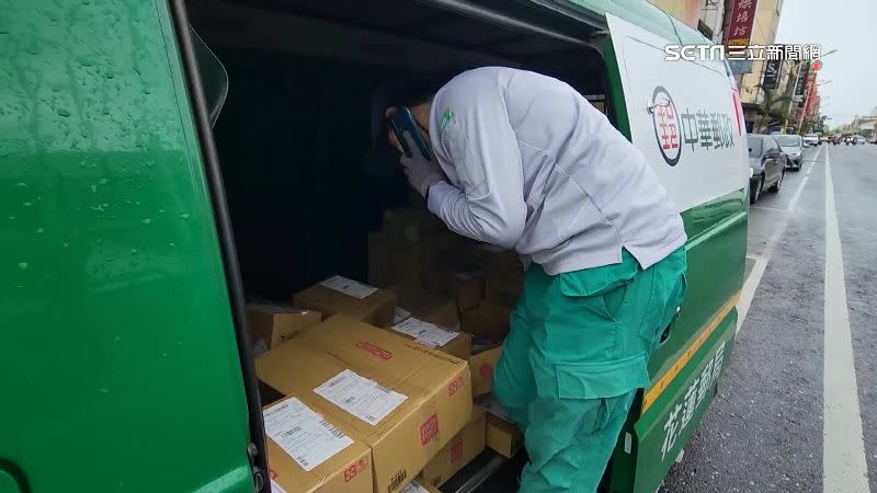 郵差在颱風天冒雨趕著送貨。