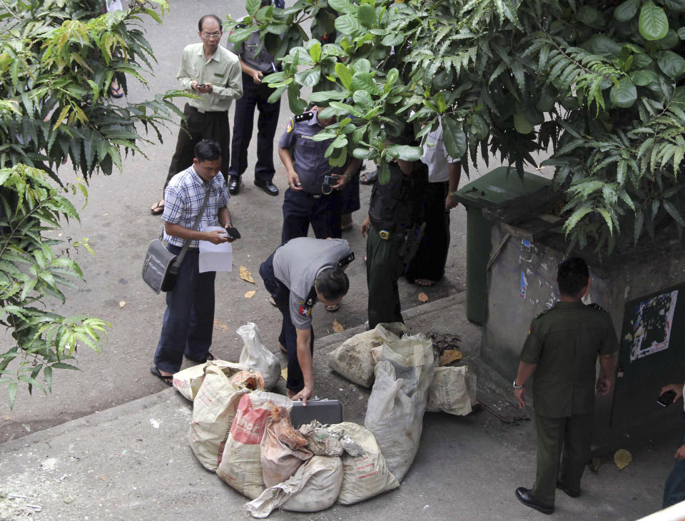 A Myanmar policeman takes a close look after a bomb squad found a suspicious looking packet in downtown Yangon, Myanmar, Tuesday, Oct. 15, 2013. Police urged vigilance after several small bombs exploded in and around Myanmar's largest city of Yangon in recent days. No one claimed responsibility for the boasts and it was not immediately clear if they were related. (AP Photo/Khin Maung Win)