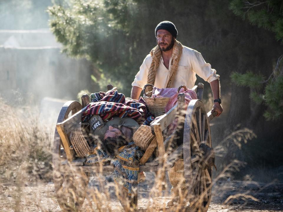 Dar Salim pushing Jake Gyllenhaal in a cart on a mountain side