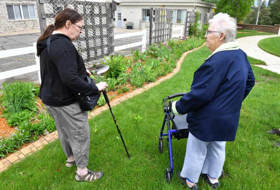 Volunteers Janice Rein and Claire Garcia talk about their work Tuesday, May 31, 2022, in a garden area near the Waite Park Public Library. 