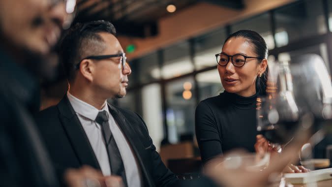 Three people, two men and woman, sitting in restaurant on business meeting.