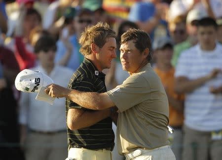 Lee Westwood (R) of England embraces Ian Poulter (L) of England at the end of their round on the 18th green during third round play in the 2010 Masters golf tournament at the Augusta National Golf Club in Augusta, Georgia, April 10, 2010. REUTERS/Brian Snyder