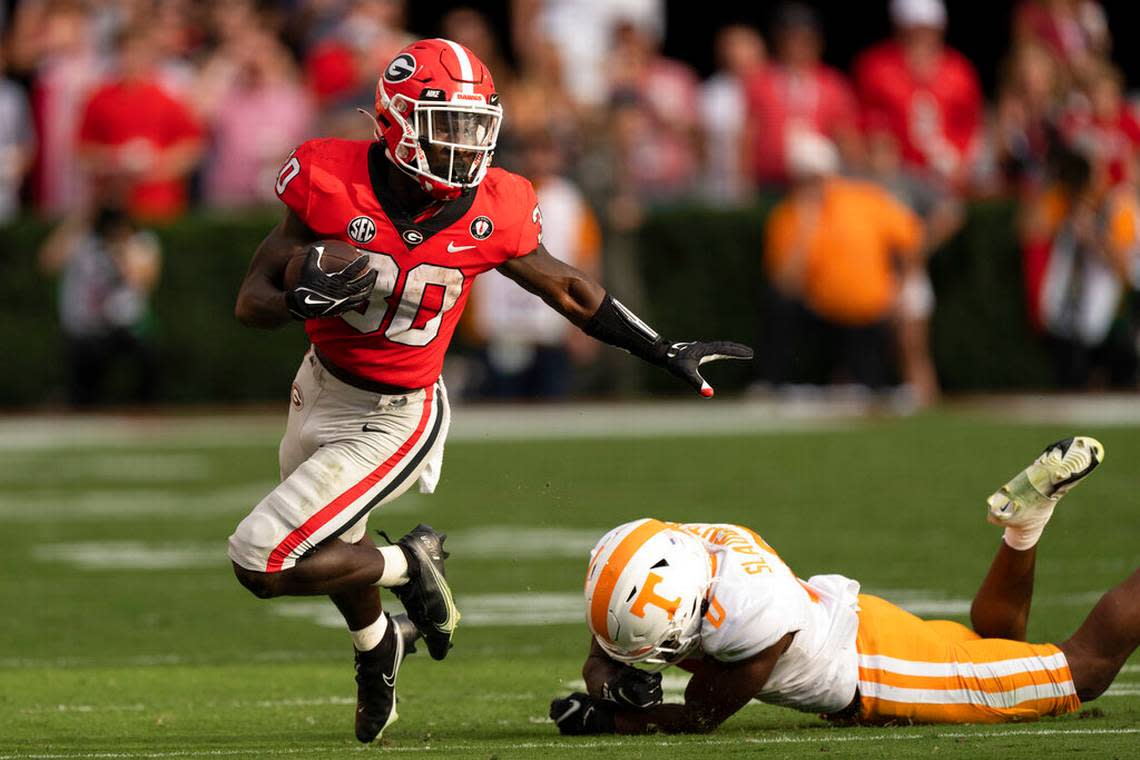 Georgia running back Daijun Edwards (30) runs away from Tennessee defensive back Doneiko Slaughter (0) after making a catch during the first half of an NCAA college football game Saturday, Nov. 5, 2022 in Athens, Ga. (AP Photo/John Bazemore)