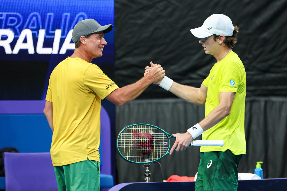 Lleyton Hewitt and Alex de Minaur embrace.