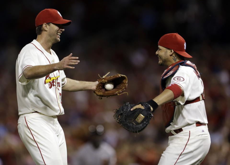 St. Louis Cardinals starting pitcher Adam Wainwright, left, is congratulated by catcher Yadier Molina after throwing a complete baseball game against the San Francisco Giants in the second game of a doubleheader on Saturday, June 1, 2013, in St. Louis. The Cardinals won 7-1. (AP Photo/Jeff Roberson)