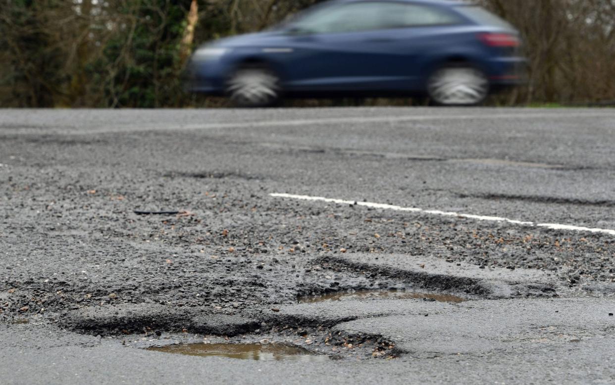 A car passing potholes in a road