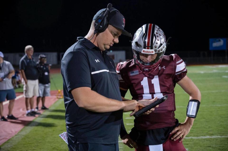 Bear River coach Tanner Mathias talks with Bear River Bruins quarterback Cole Stowers (11) in the second half of the game on Thursday, Sept. 14, at Bear River High School in Grass Valley.
