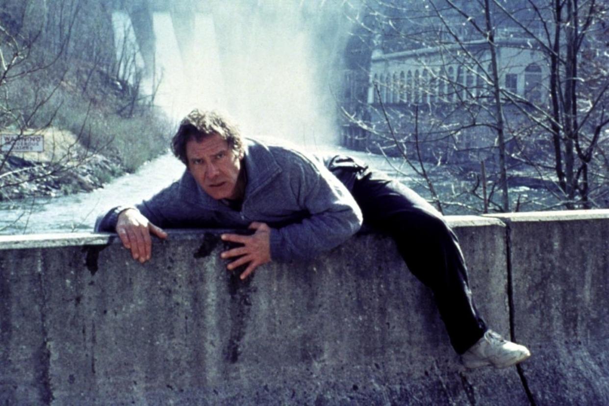 a man climbing over a stone wall