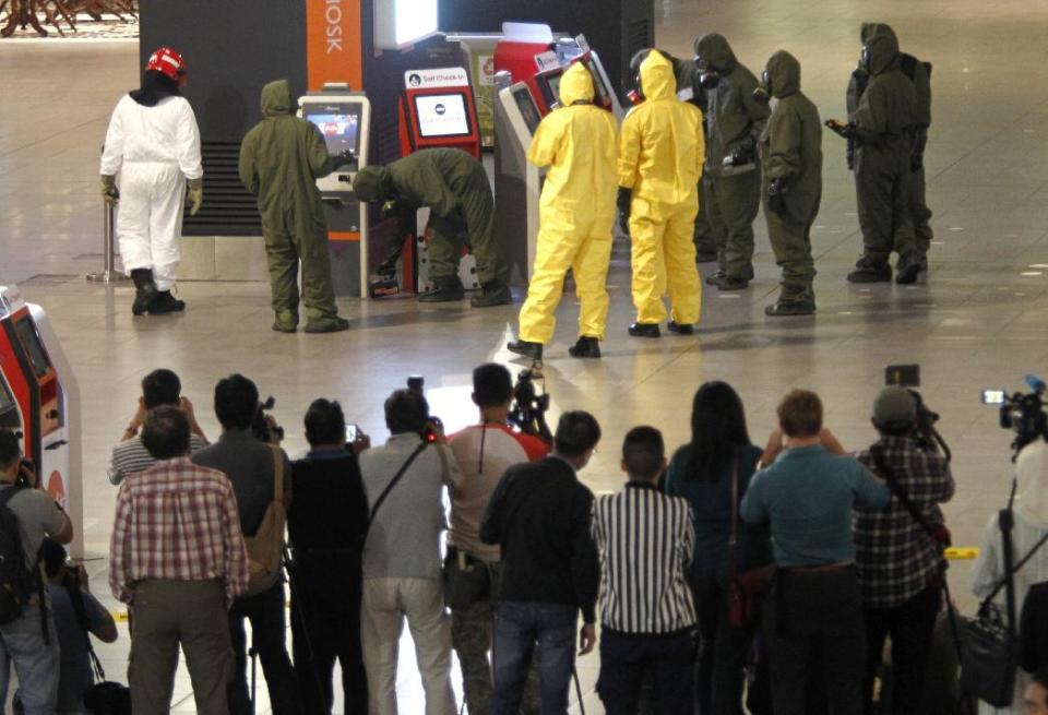 Hazmat crews investigate the check in kiosk machines at Kuala Lumpur International Airport 2 in Sepang, Malaysia on Sunday, Feb. 26, 2017. Malaysian police ordered a sweep of Kuala Lumpur airport for toxic chemicals and other hazardous substances following the killing of Kim Jong Nam. (AP Photo/Daniel Chan)