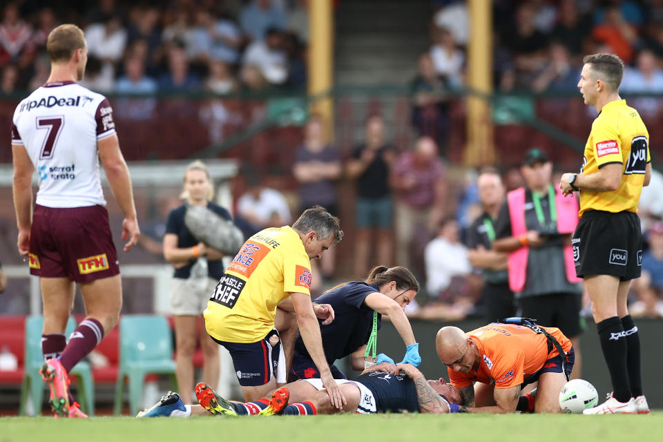 Jake Friend is attended to by team trainers after head knock during the round one NRL match between the Sydney Roosters and the Manly Sea Eagles at the Sydney Cricket Ground, on March 13, 2021