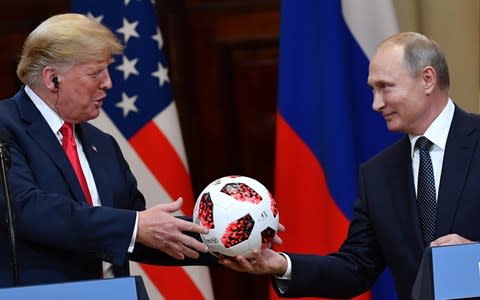 Vladimir Putin hands President Trump a football from the 2018 World Cup hosted by Russia. - Credit: YURI KADOBNOV /AFP