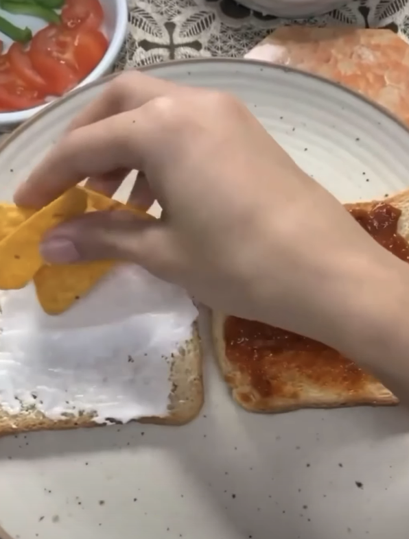 putting doritos on top of a slice of bread