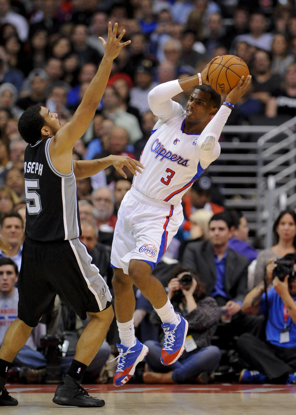Los Angeles Clippers guard Chris Paul (3) looks around San Antonio Spurs guard Cory Joseph (5) for the open man in the first half of a NBA basketball game, Tuesday, Feb. 18, 2014, in Los Angeles.(AP Photo/Gus Ruelas)