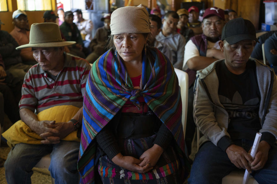 Magdalena Tepaz, center, and Manuel de Jesus Tulul, right, parents of Wilmer Tulul, wait for the start of a community meeting in Tzucubal, Guatemala, Wednesday, June 29, 2022. Wilmer and his cousin Pascual, both 13, were among the many dead discovered inside a tractor-trailer on the edge of San Antonio, Texas, on Monday. (AP Photo/Moises Castillo)