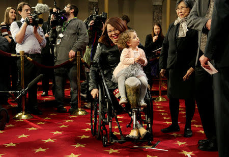 FILE PHOTO: Senator Tammy Duckworth (D-IL) carries her daughter Abigail during a mock swearing in with U.S. Vice President Joe Biden during the opening day of the 115th Congress on Capitol Hill in Washington, U.S., January 3, 2017. REUTERS/Joshua Roberts/File Photo