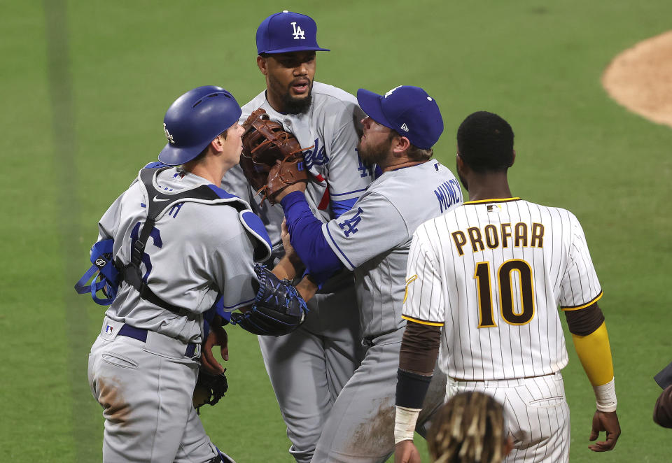 SAN DIEGO, CALIFORNIA - APRIL 16: Will Smith #16 and Max Muncy #13 hold back Dennis Santana #77 of the Los Angeles Dodgers as he challenges Jurickson Profar #10 after hitting Jorge Mateo #3 of the San Diego Padres with a pitch looks on during the tenth inning of a game at PETCO Park on April 16, 2021 in San Diego, California. (Photo by Sean M. Haffey/Getty Images)