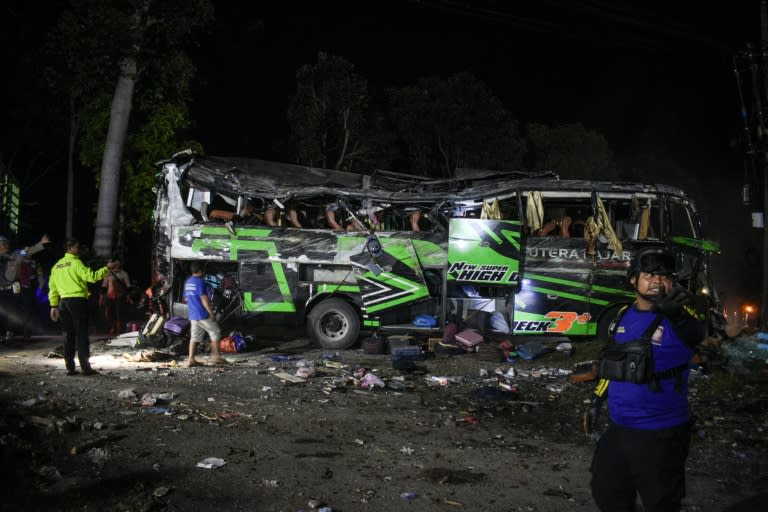 Officers check the debris and belongings of passengers after a bus crash on Java island (Timur MATAHARI)